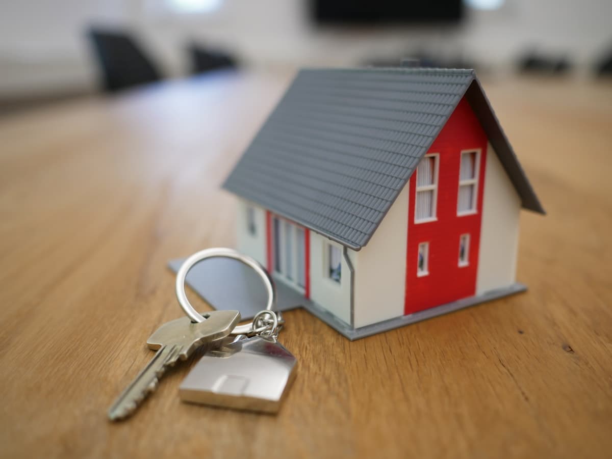 Litet modellhus och nycklar på ett träbord